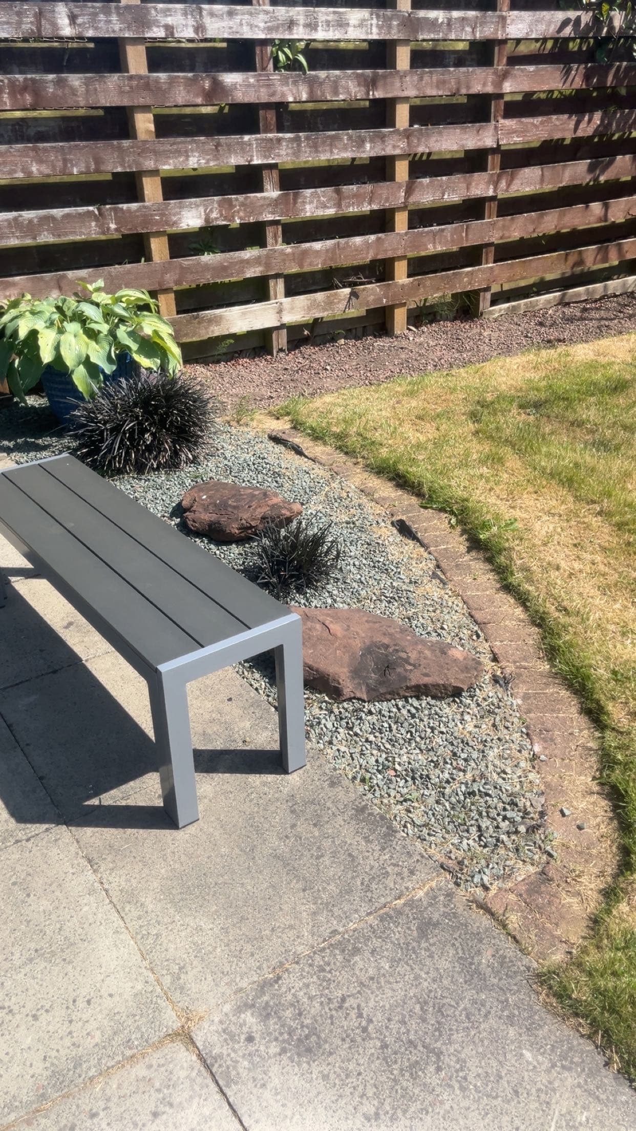 Garden landscaping with grey stone, feature rocks and a seating area completed by RML Ground Maintenance in Portpatrick