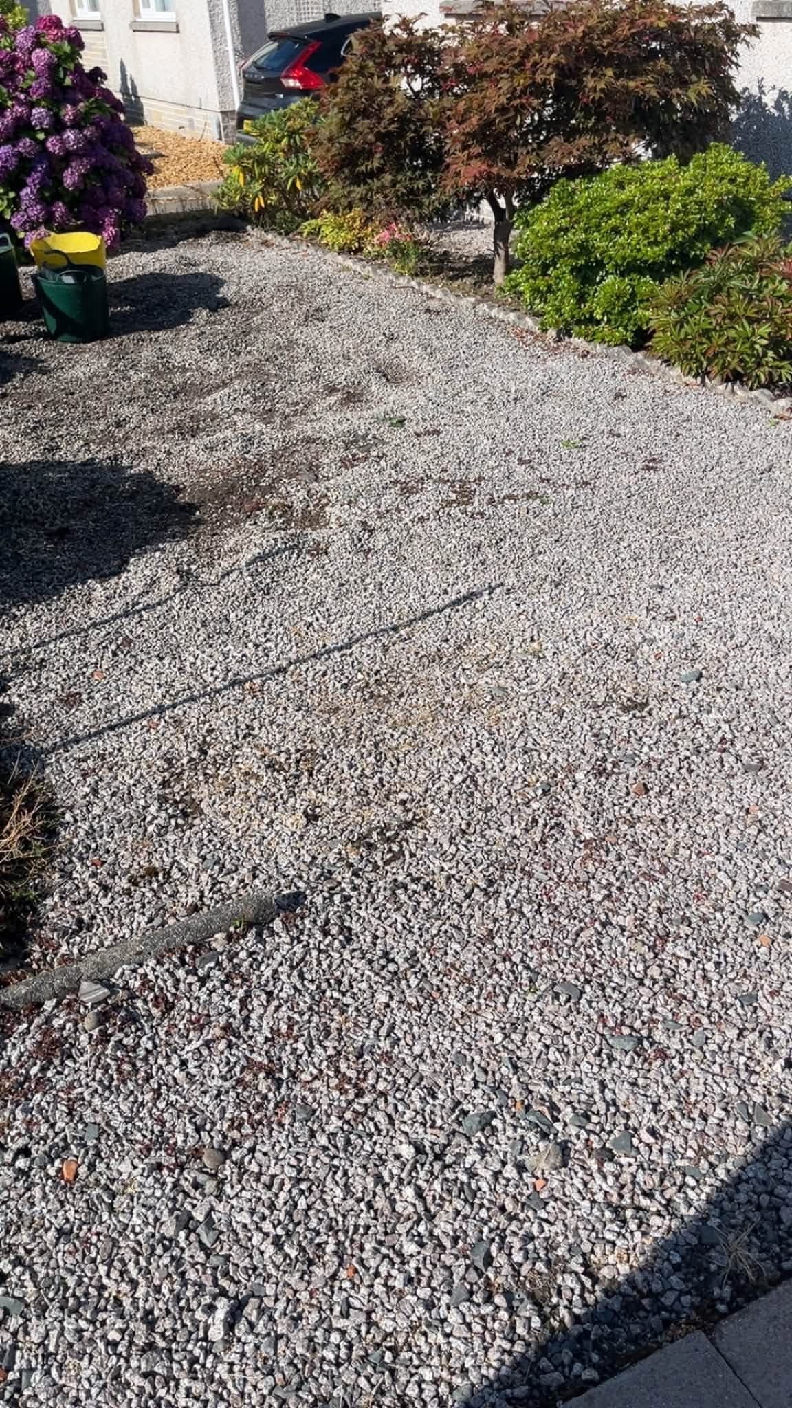 Overgrown gravel area before garden landscaping work by RML Ground Maintenance in Wigtown
